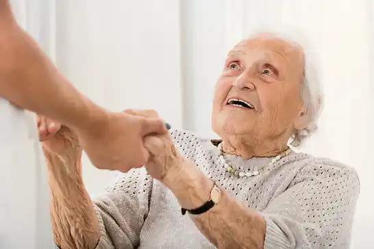 Pflegeteam mit Hand und Herz, eine alte Dame hält die Hand eines