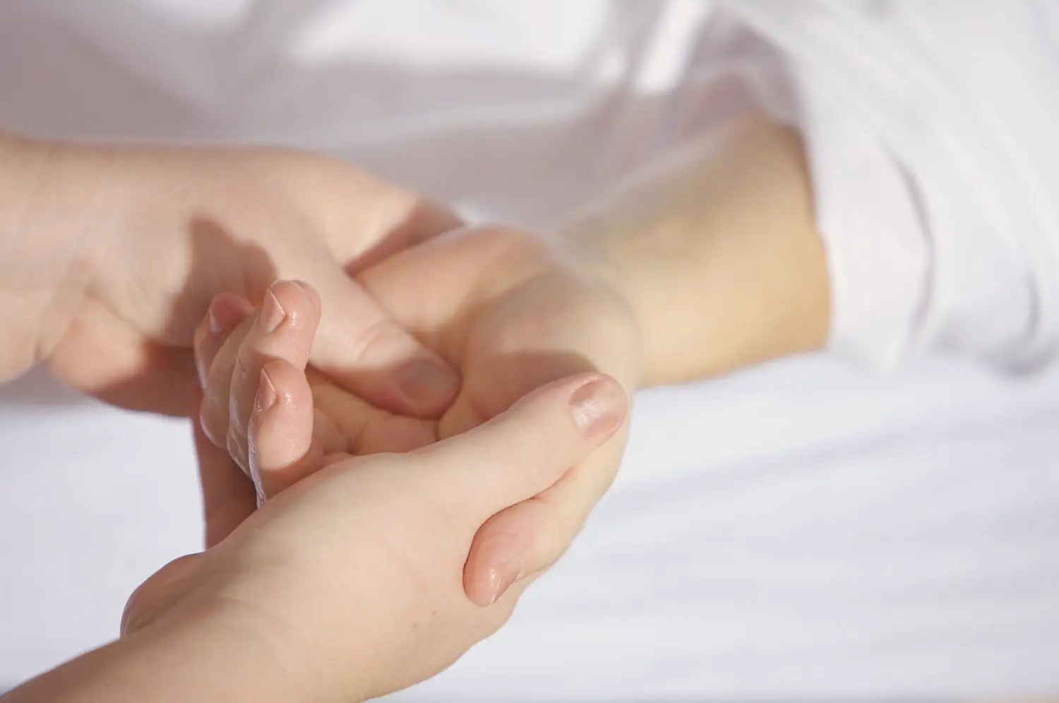 Pflegeteam mit Hand und Herz, Krankenschwester massiert die Hand eines Patienten