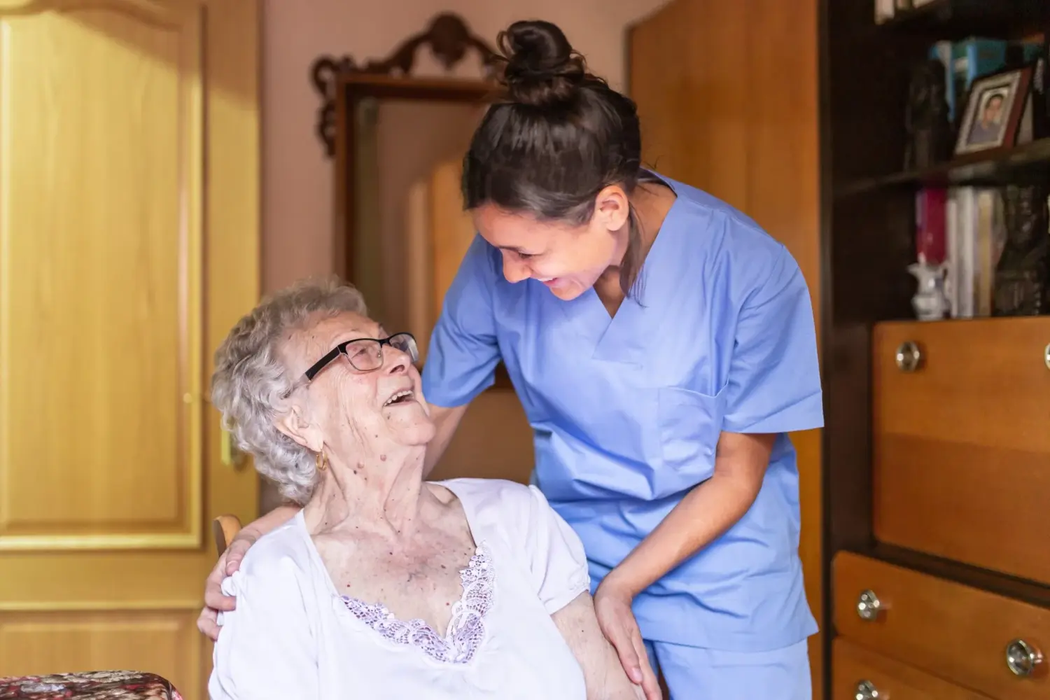 Pflegeteam mit Hand und Herz, Krankenschwester kümmert sich um eine alte Dame