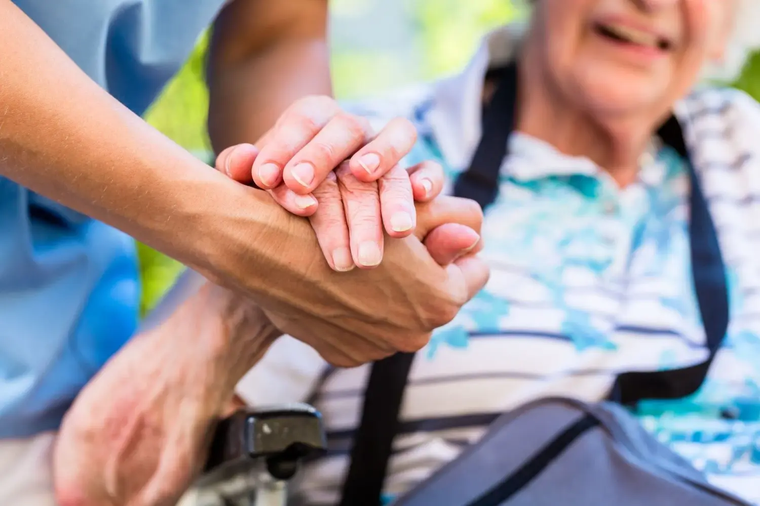 Pflegeteam mit Hand und Herz, eine Krankenschwester legt einer alten Dame tröstend die Hände auf die Schultern