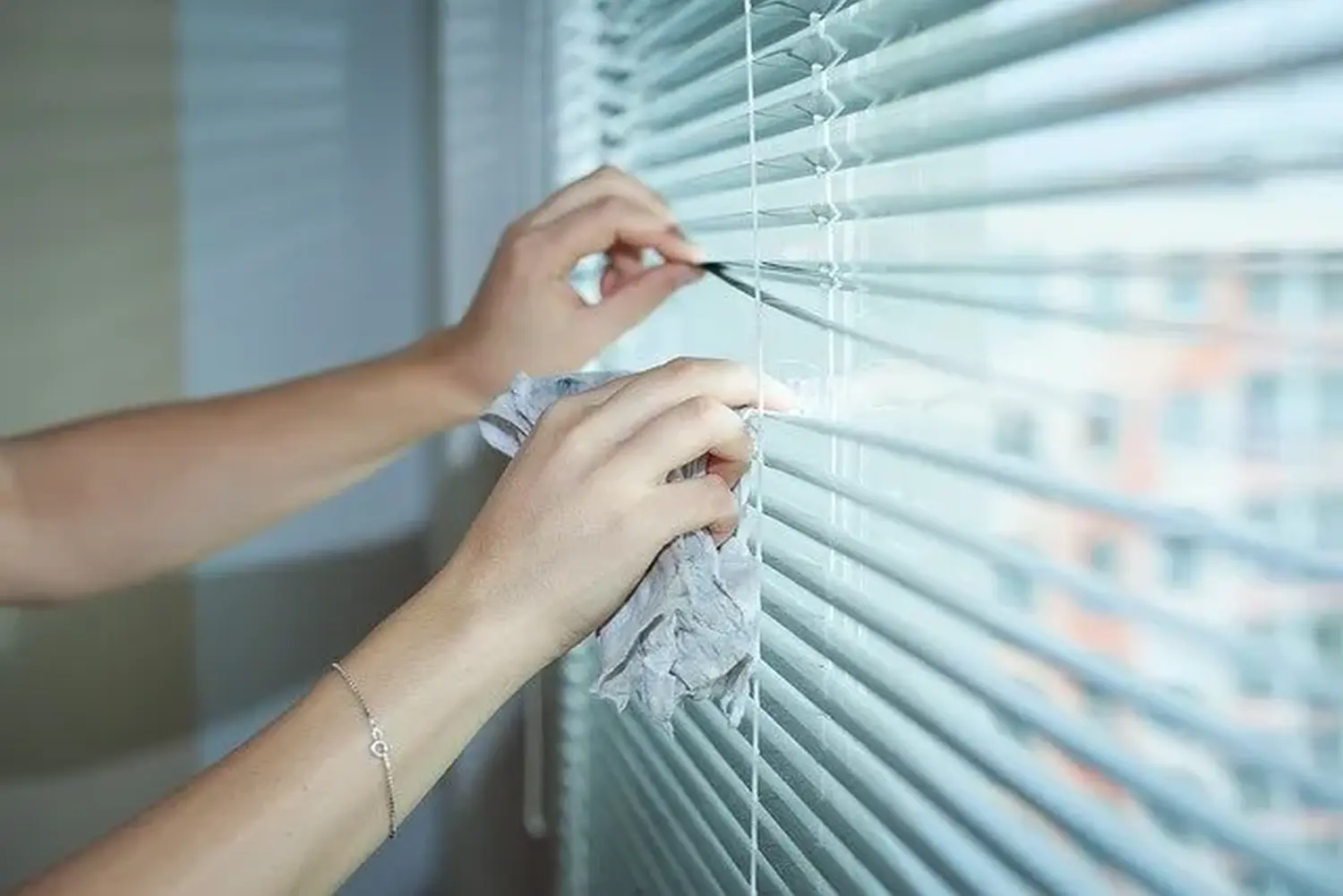 Pflegeteam mit Hand und Herz, Frau putzt das Fenster mit verbundenen Augen